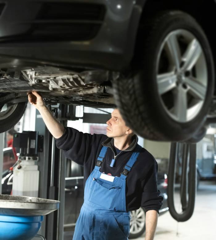 Mechanic in uniform is working in auto service Mechanic in uniform is working in auto service